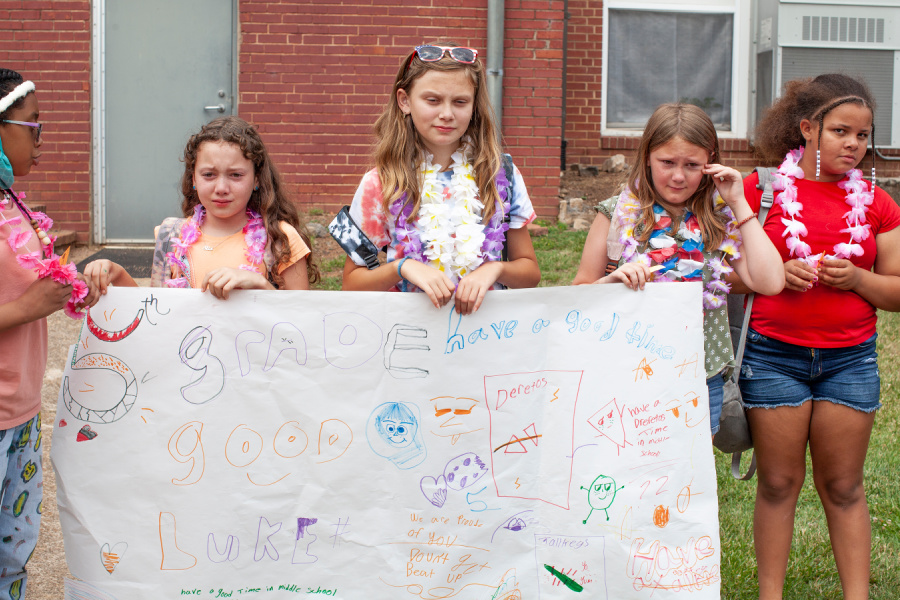 Group of sad Cooleemee Elementary students hold signs wishing fifth grade students a great year in middle school next year as they leave Cooleemee Elementary. 
